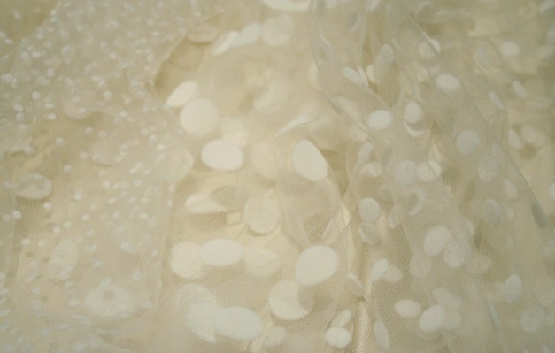 Flock spot tulle, shown in ivory, is available in three spot sizes.
